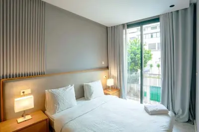 a bedroom with a bed and a large window at Résidence B-Livin - La Ferme Bretonne in Casablanca