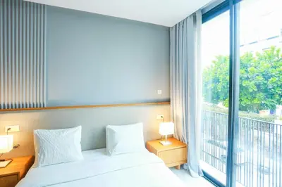 a bedroom with a bed and a large window at Résidence B-Livin - La Ferme Bretonne in Casablanca
