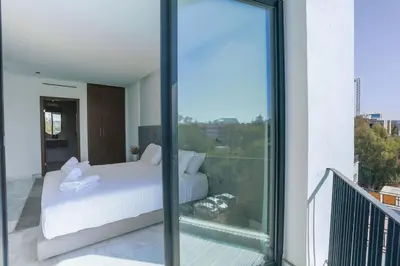 a bedroom with a white bed on a balcony at Résidence B Livin - Oasis in Casablanca