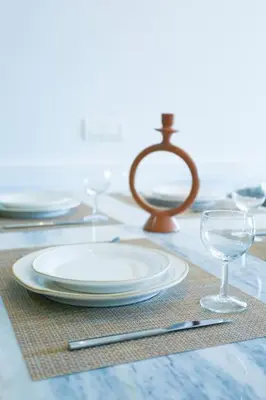 a table with a plate and glasses on a table at Résidence B Livin - Oasis in Casablanca