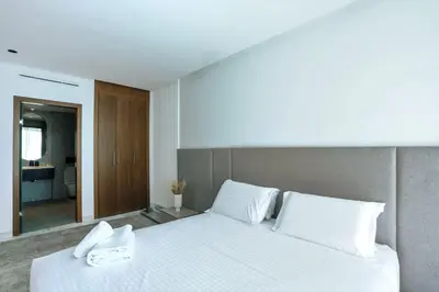 a bedroom with a large white bed with a mirror at Résidence B Livin - Oasis in Casablanca