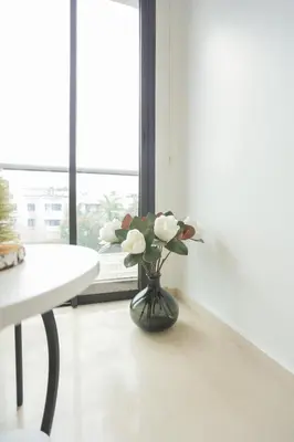 a vase with white flowers in a room with a window at Résidence Anfa Sunset - Ain Diab Casablanca Beach in Casablanca