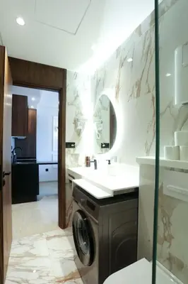 a bathroom with a sink and a washing machine at Résidence Palm - Palmiers in Casablanca