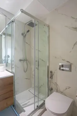 a bathroom with a glass shower with a toilet at Résidence Ronomo - Racine in Casablanca