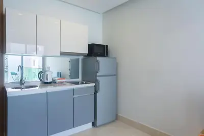 a kitchen with a refrigerator and a sink at Résidence Ronomo - Racine in Casablanca