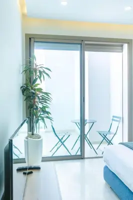 a bedroom with a sliding glass door with a plant at Résidence Ronomo - Racine in Casablanca