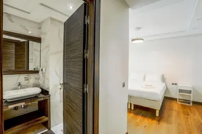 a white bathroom with a sink and a bed at Résidence Urban Square D52 in Casablanca
