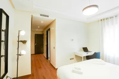 a bedroom with two beds and a desk with a laptop at Résidence Urban Square D52 in Casablanca