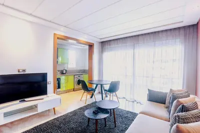 a living room with a tv and a table and chairs at Résidence Smalto - Bd Anfa in Casablanca