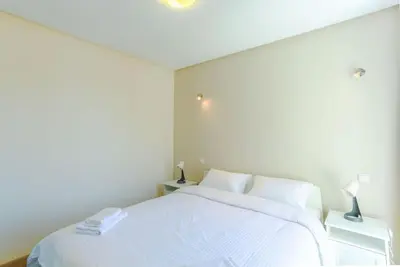 a bedroom with a white bed and two night stands at Résidence Bd Anfa in Casablanca