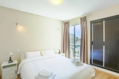 a bedroom with a large white bed and a window at Résidence Bd Anfa in Casablanca