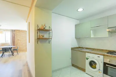 a kitchen with a washing machine and a table at Résidence Bd Anfa in Casablanca