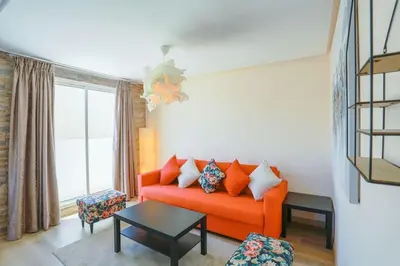 a living room with an orange couch and a window at Résidence Bd Anfa in Casablanca