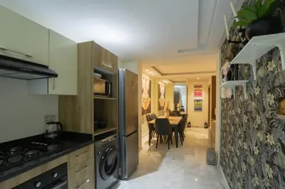 a kitchen with a refrigerator and a dining room at Résidence Marie Césaire - Maarif in Casablanca