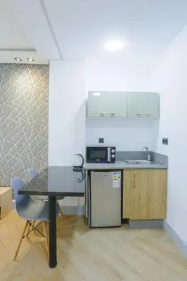 a kitchen with a table and a sink and a microwave at Résidence Marie Césaire - Maarif in Casablanca