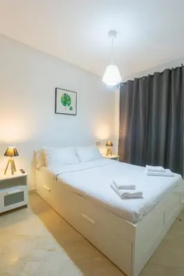 a bedroom with a large white bed with a window at Résidence Liberté in Casablanca