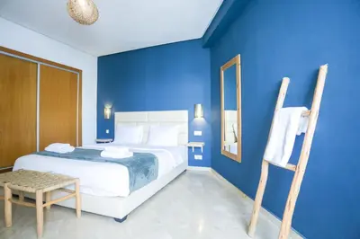 a blue bedroom with a bed and a chair at Résidence Liberté in Casablanca