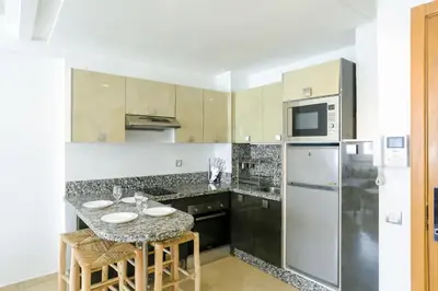a kitchen with a table and a refrigerator at Résidence Liberté in Casablanca
