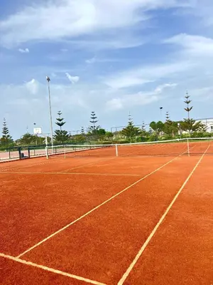 a tennis court with a net on top of it at Appartement Moderne à OlaBlanca2 in Sidi Rahal