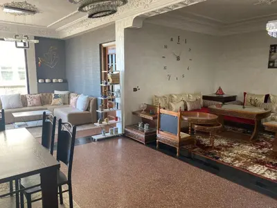 a living room with couches and a clock on the wall at اقامة الهام in Casablanca