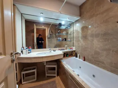 a bathroom with a sink and a tub and a person in the mirror at Appartement chic avec Terrasse in Casablanca