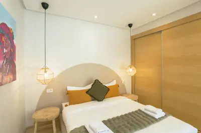 a bedroom with a bed and a chair and lights at Résidence de Nice in Casablanca