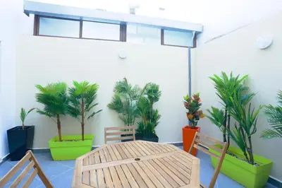 a room with a table and chairs and palm trees at Résidence de Nice in Casablanca