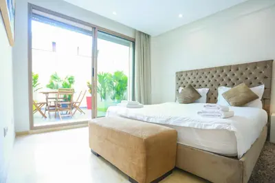 a bedroom with a large bed and a large window at Résidence de Nice in Casablanca