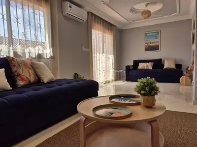 a living room with a blue couch and a table at My Cosy Place Rabat - Cosy Apartement Avenue de France in Rabat
