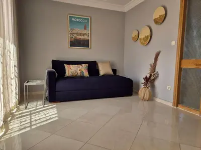 a living room with a blue couch in a room at My Cosy Place Rabat - Cosy Apartement Avenue de France in Rabat