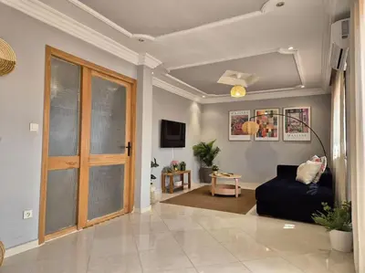 a living room with a couch and a sliding glass door at My Cosy Place Rabat - Cosy Apartement Avenue de France in Rabat