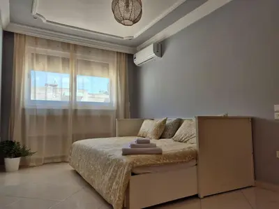 a bedroom with a bed with a large window at My Cosy Place Rabat - Cosy Apartement Avenue de France in Rabat