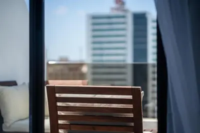 a wooden chair sitting in front of a window at Studio Cosy Proche Gares & Mosqué Hassan II in Casablanca