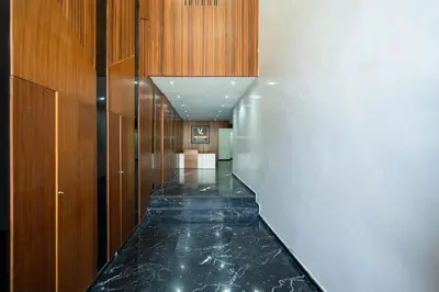 a hallway with a black marble floor and wooden walls at Studio Cosy Proche Gares & Mosqué Hassan II in Casablanca