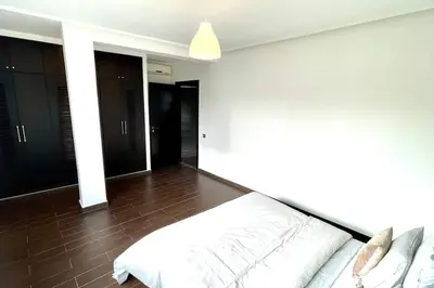 a bedroom with a white bed and a brown floor at Luxury villa with private pool in Casablanca