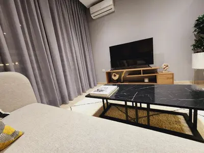 a living room with a tv and a table at The Twenty-Six Palmier by IB Signature - Design 1Bedroom Apt with Wifi, Parking, Self check-in, 24 x7 Security - City View with terrace - Walk to Cafes! City Centre, Tram in Casablanca