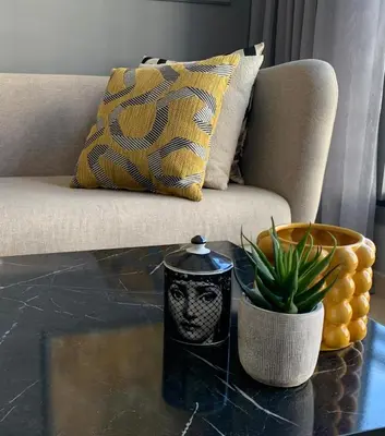 a living room with a couch and a table with a plant at The Twenty-Six Palmier by IB Signature - Design 1Bedroom Apt with Wifi, Parking, Self check-in, 24 x7 Security - City View with terrace - Walk to Cafes! City Centre, Tram in Casablanca