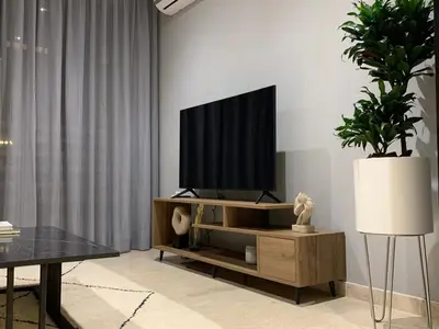 a living room with a flat screen tv on a entertainment center at The Twenty-Six Palmier by IB Signature - Design 1Bedroom Apt with Wifi, Parking, Self check-in, 24 x7 Security - City View with terrace - Walk to Cafes! City Centre, Tram in Casablanca