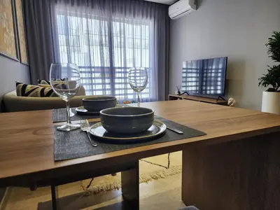 a table with two bowls and wine glasses on it at The Twenty-Six Palmier by IB Signature - Design 1Bedroom Apt with Wifi, Parking, Self check-in, 24 x7 Security - City View with terrace - Walk to Cafes! City Centre, Tram in Casablanca