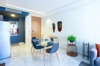 a dining room with a glass table and blue chairs at #23 New Charming Casablanca Retreat/keyless door in Casablanca
