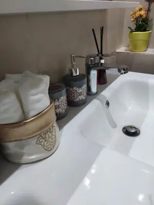 a bathroom sink with towels and a faucet at Chabili Appartements in Temara