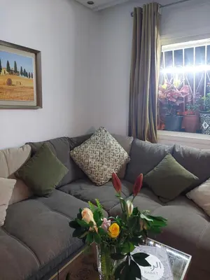 a living room with a couch and a table with flowers at Chabili Appartements in Temara