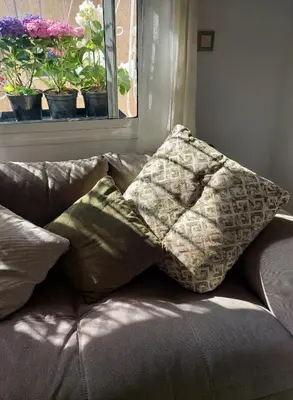 two pillows sitting on top of a couch with a window at Chabili Appartements in Temara