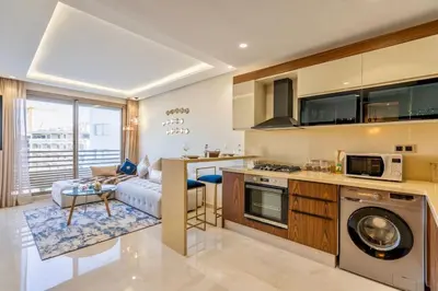 a kitchen and living room with a couch and a table at Charming & Airy Flat - Perfect for Relaxation in Casablanca
