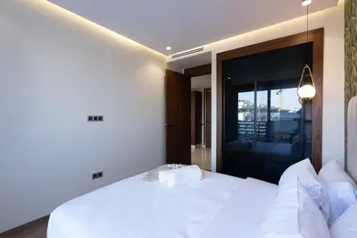 a bedroom with a white bed and a large window at Charming & Airy Flat - Perfect for Relaxation in Casablanca