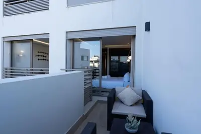 a balcony with a bed and a chair in a room at Charming & Airy Flat - Perfect for Relaxation in Casablanca