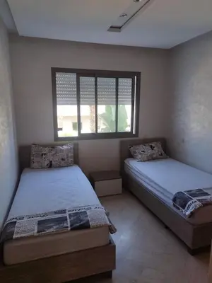 a bedroom with two beds and a window at Best appartement pools view at Mansouria in Mohammedia