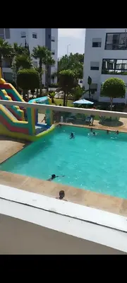 a swimming pool with a slide and people in the water at Best appartement pools view at Mansouria in Mohammedia