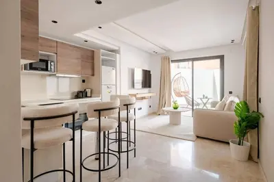 a kitchen with bar stools and a living room at 1 Bedroom with Terrace Casablanca City Center in Casablanca