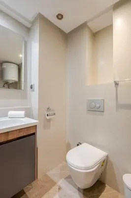 a white bathroom with a toilet and a sink at 1 Bedroom with Terrace Casablanca City Center in Casablanca